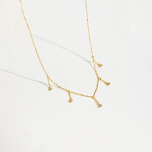 Elegant gold chain necklace featuring five circular zircon pendants on a clean white background