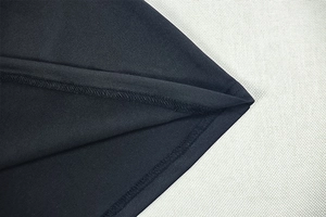 Detailansicht der Doppelnaht am Saum und feiner Textur auf schwarzem Strickkleidstoff