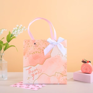 Sac cadeau aquarelle rose avec nœud blanc et texte Thank You pour célébrations festives
