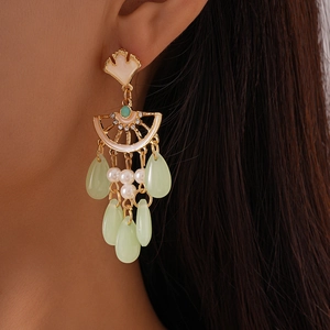 Gros plan détaillé de boucles d'oreilles rétro feuille de ginkgo avec glands sur un mannequin