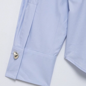 Women's light blue striped long sleeve shirt featuring a designer silver irregular button