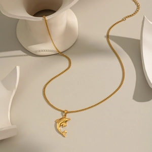 Gros plan d'un collier avec pendentif dauphin en acier inoxydable plaqué or 18 carats