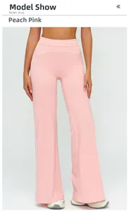 Detailed close-up of high-waisted peach pink yoga pants with white decorative stitching