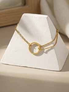 Detail of 18k gold plated bracelet with minimalist ring and asymmetric beaded chain