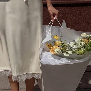 Gros plan sur la jupe midi en soie beige avec dentelle délicate et bouquet de fleurs