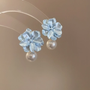 Detailed macro view of light blue resin flower earrings with elegant pearl pendant drops