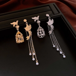 Asymmetric bird cage earrings with pearl tassels in gold and silver finish details