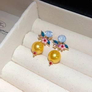 Detailaufnahme von Vintage-Blumenperlenohrringen mit blauen Steinen in Schmuckbox