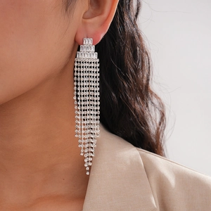 Macro side view of silver tassel earrings with zircons hanging elegantly on ear