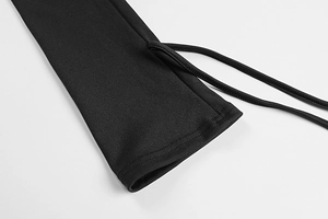 Detail of black long sleeve dress featuring fine ribbed texture and adjustable side drawstrings
