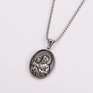 Macro detail of oval stainless steel pendant with embossed religious figure on box chain