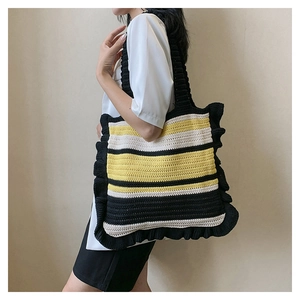 Detailed texture of black yellow striped crochet tote bag with ruffled edges