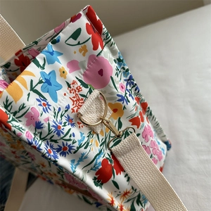 Large floral canvas tote bag with colorful print and golden metal lobster clasp detail