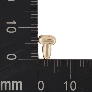 Macro shot of a 6mm gold bubble letter pendant with a ruler for size reference