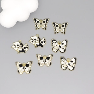Set of eight gothic butterfly skull alloy charms with black white enamel and gold trim
