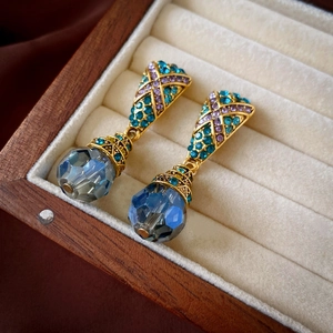 Détail de boucles d'oreilles vintage françaises avec cristaux bleus dans un écrin