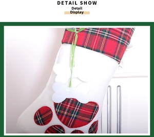 Detailed close-up of Christmas cat paw stocking with red and green plaid and plush bone