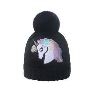 Berretto invernale in maglia da donna con ricamo unicorno e pompon nero in ecopelliccia
