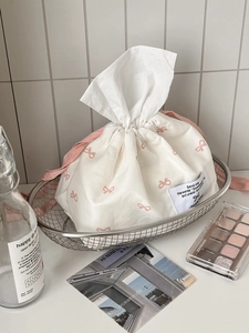 Close-up of cream tissue holder with pink bow pattern in a cozy home setting