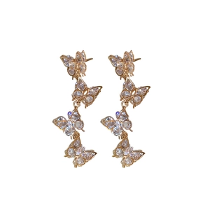 Elegant gold butterfly tassel earrings with sparkling zircon stones on a white background