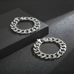 Polished and brushed titanium steel cuban link bracelets shown on a geometric display