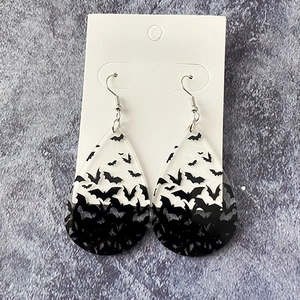 Macro detail of teardrop bat earrings with gradient finish and metal hooks for Halloween