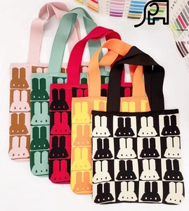 Close-up of knit tote bags featuring colorful rabbit geometric patterns in various colors