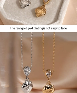 Macro detail of PVD gold-plated strawberry pendant with pear-cut zircon and fine link chain