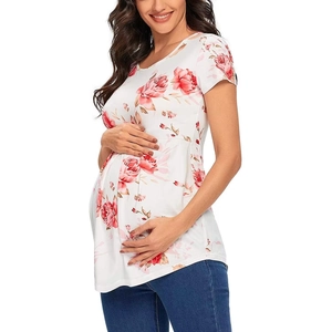 Nahaufnahme des weißen Umstandsshirts mit rot-rosa Blumendruck und Rüschendetails