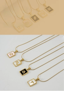 Macro detail of zodiac sign pendant on gold snake chain with shell inlay