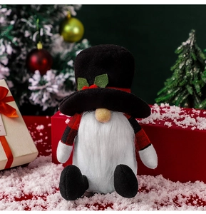 Close-up of a Christmas gnome doll with a tall black hat and fluffy white beard in a snowy setting