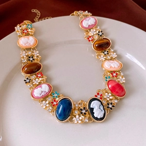 Détail du collier camée vintage français avec pierres précieuses sur plateau blanc