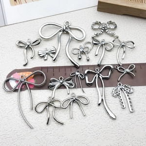 Collection of silver bow charms for DIY jewelry including hollow and diamond designs