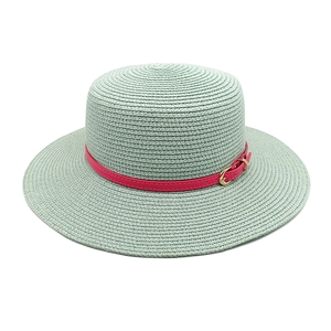Detail of mint green woven straw hat with pink leather belt and gold metal buckle