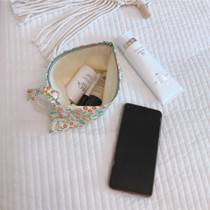 Floral cotton pouch showing interior capacity for phone and skincare cosmetics