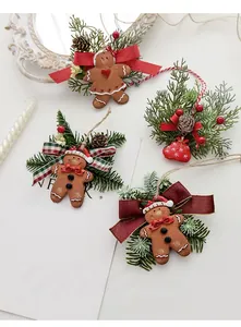 Detailed view of gingerbread ornaments with pine needles, cones and plaid bows
