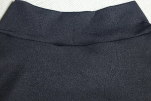 Detail of a black high-neck knit dress featuring precise double-layer stitching