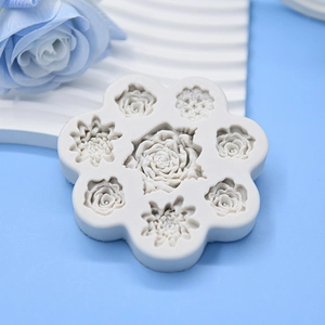 White silicone mold for fondant roses and daisies on a light blue decorative background