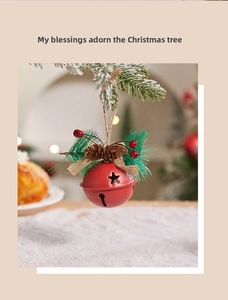 Close-up of a red metal Christmas bell with star cutouts and festive pine needle decor