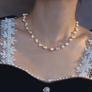 Elegant double-layer woven pearl necklace with gold beads on a neck model