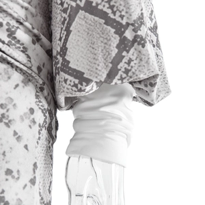 Detailed view of elastic white cuffs and grey snakeskin print on long lantern sleeves
