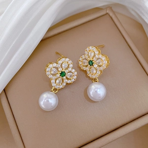 Detail of gold clover earrings with green stone, clear zircons and white pearls