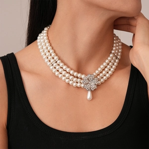 Detail of multi-layer pearl necklace with a rhinestone flower buckle and teardrop pendant