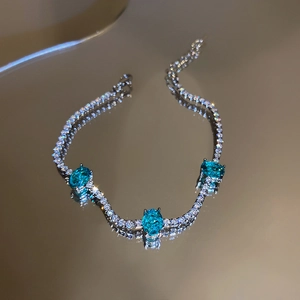 Detailed close-up of blue oval crystals and white rhinestones on silver bracelet