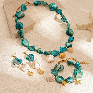 Detailed macro view of beach style necklace set with teal shells and golden sea charms