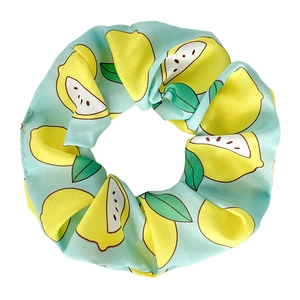 Detailed view of light blue satin scrunchie featuring fresh yellow lemon patterns