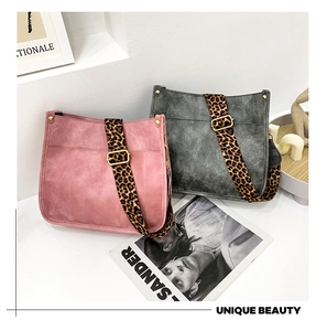 Close-up of vintage faux suede tote bags in pink and grey with leopard print straps