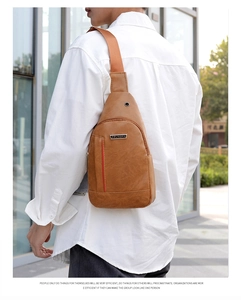 Rear view of brown PU leather sling bag on model featuring red stripe and metal logo