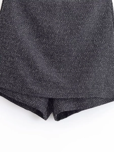 Close-up of black and silver tweed fabric texture on a stylish fashion skirt suit