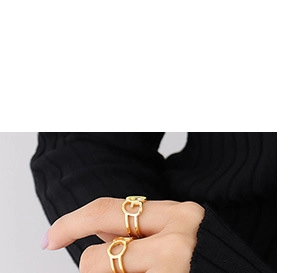 Close-up of a luxury gold-plated letter G ring worn over black knit clothing